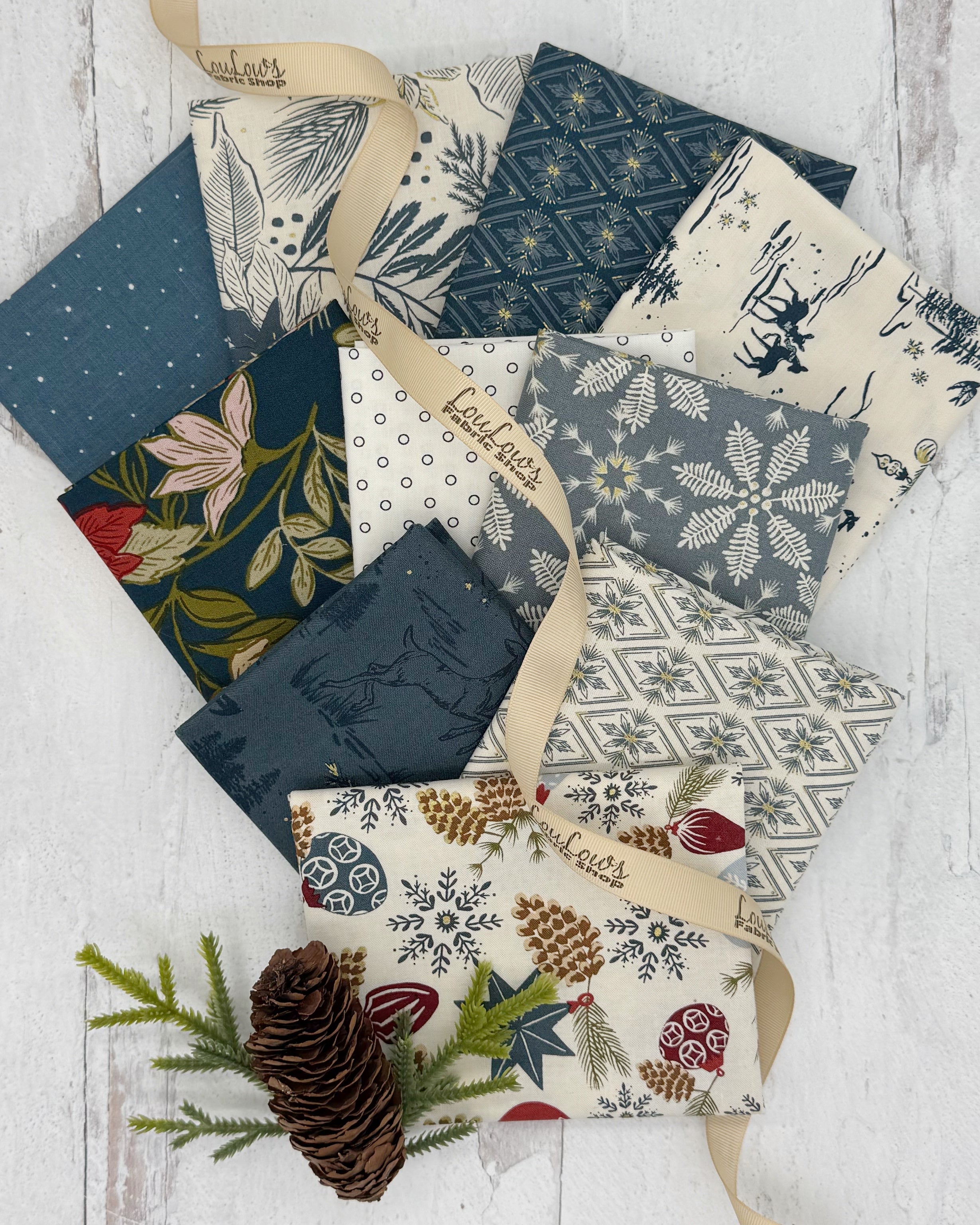 Collection of 10 fat quarters with holiday prints on blue and cream background fabrics