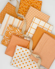 Collection of 10 fat quarters with a bright orange background or ivory background with orange accents. 