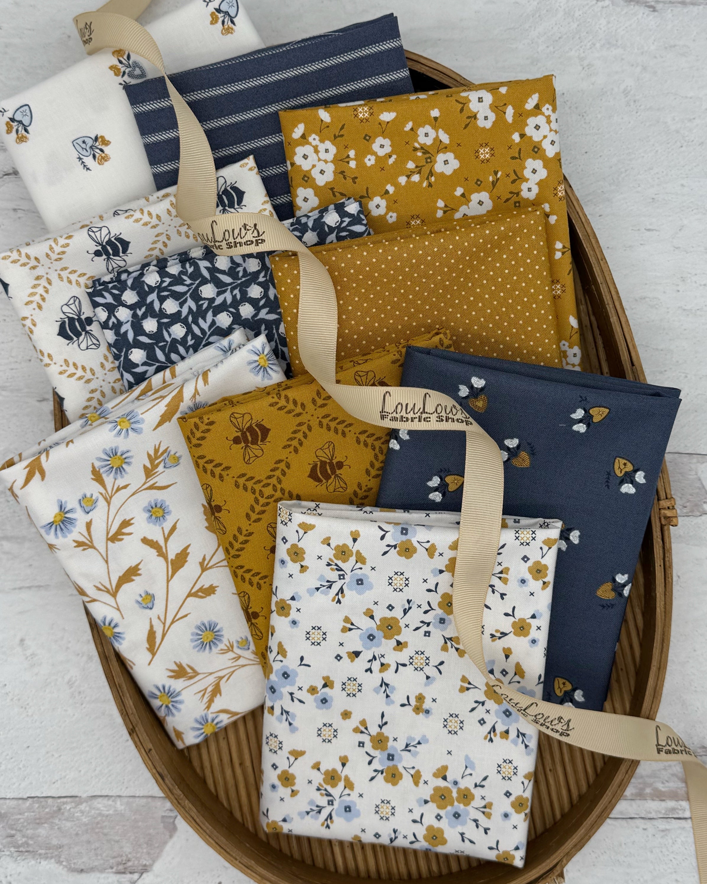 10 fat quarters in cream, gold and navy blue. Florals, bees, stripes and dots. 
