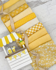 10 bright yellow fat quarters with floral, gingham, geometric and striped prints. 