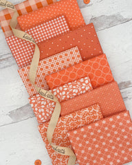 10 coral fat quarters with geometric, floral and gingham prints. 