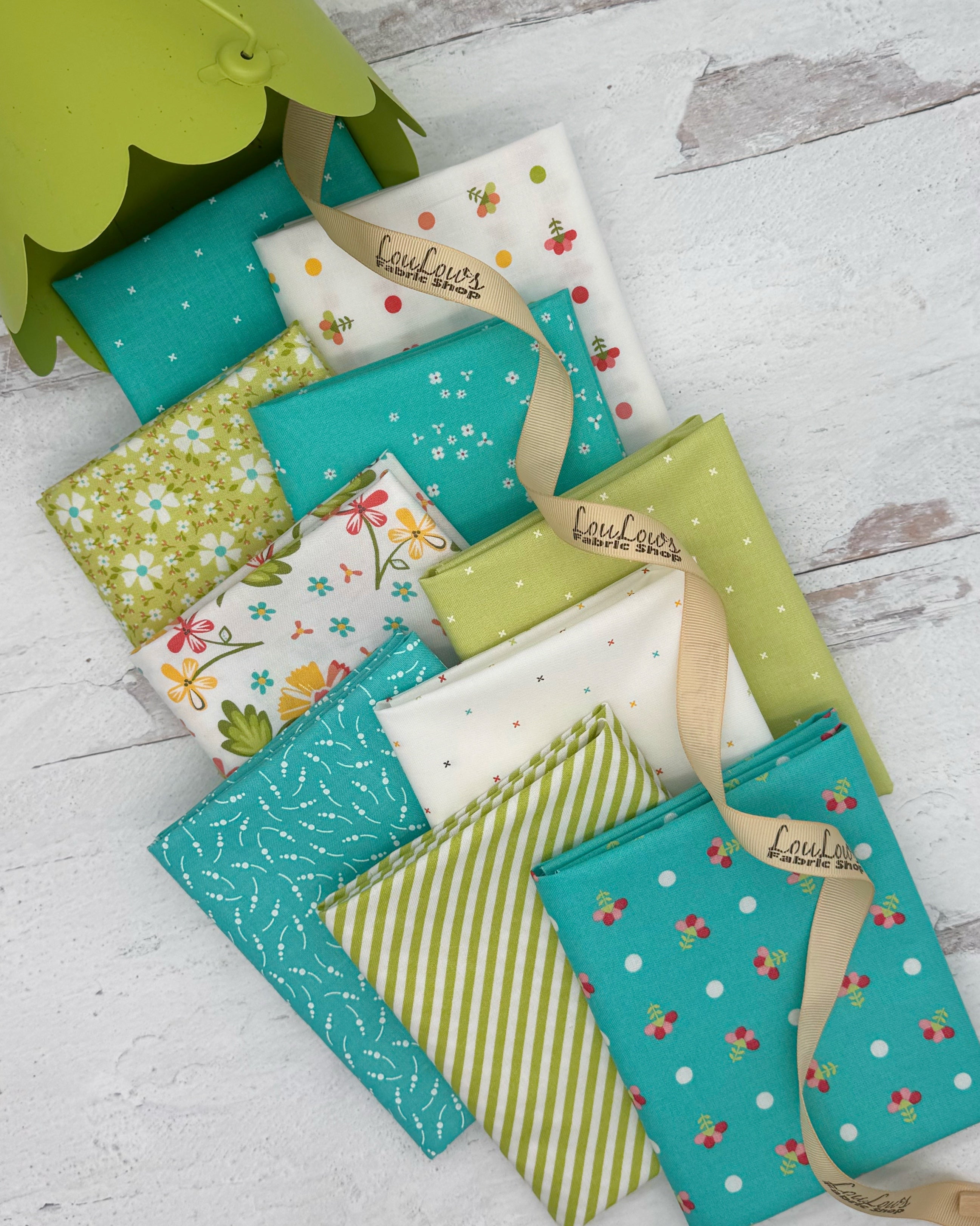 Collection of 10 fat quarters in bright aqua, white and soft apple green fabrics in florals, stripes and geometrics. 