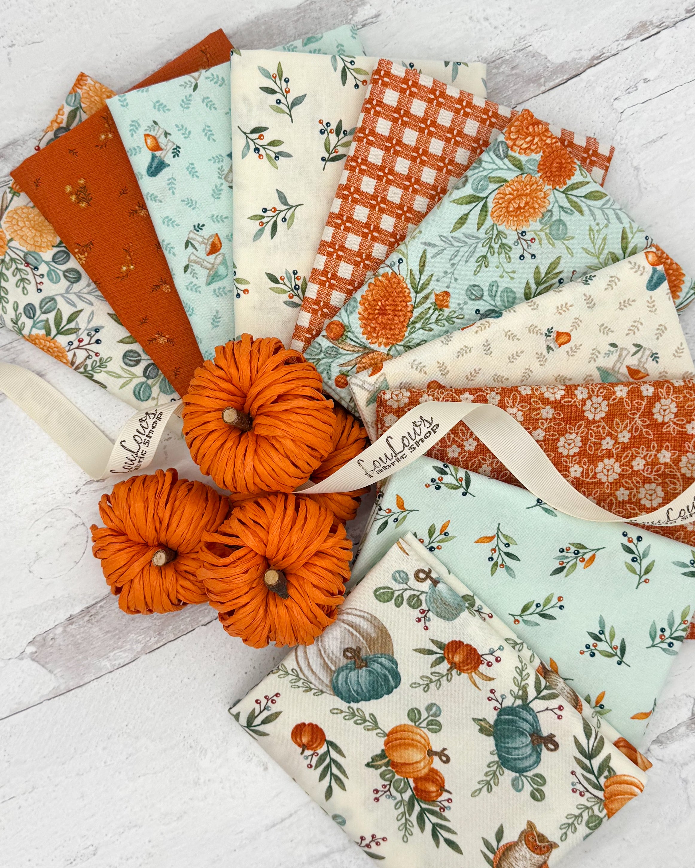 10 fat quarters with cream, burnt orange and aqua backgrounds with fall floral and gingham prints. 