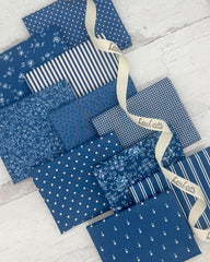 Collection of 10 fat quarters in a denim blue color. Prints include dots, florals, stripes and geometrics. 