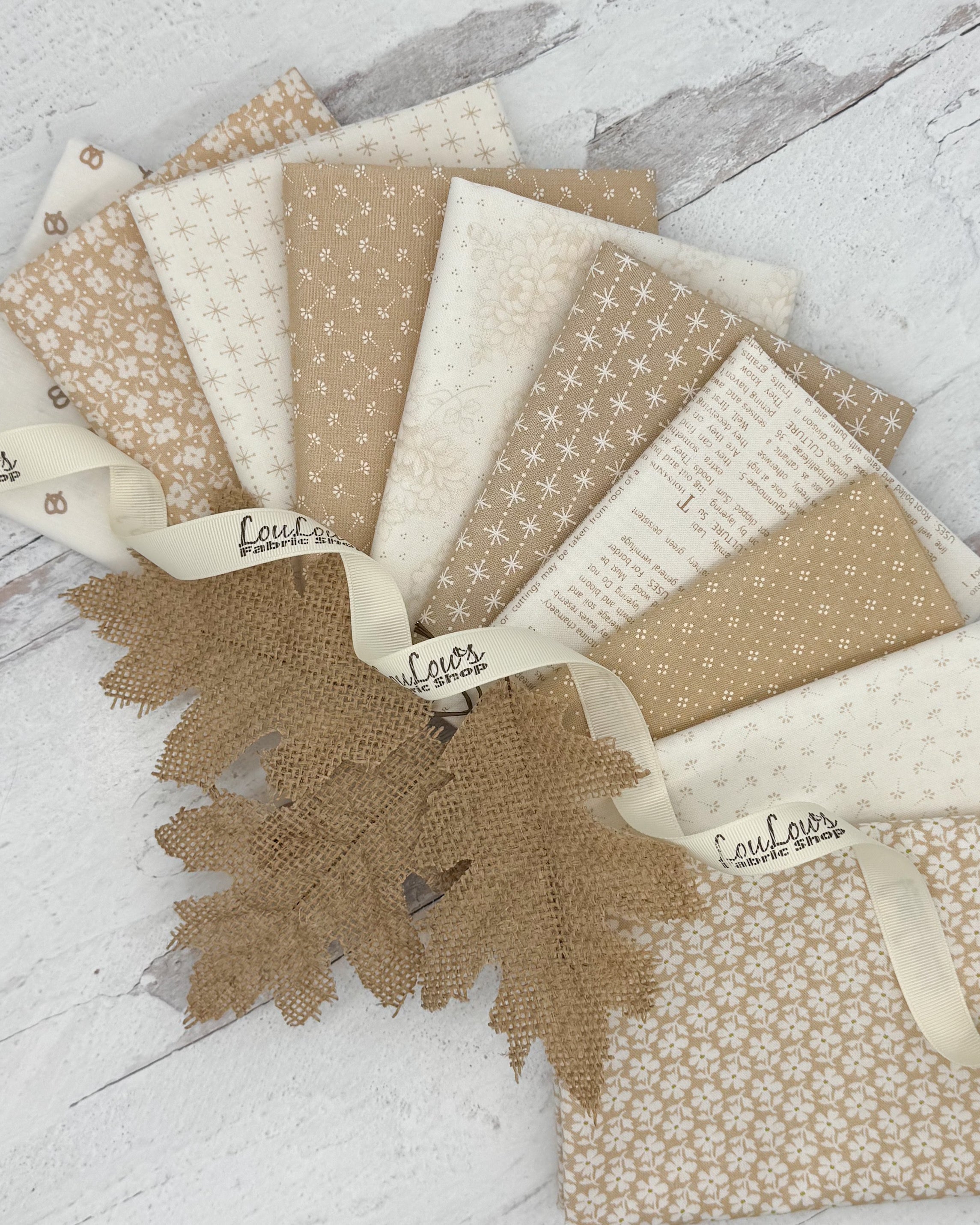 10 fat quarters with cream or tan backgrounds with a variety of floral, dot and geometric prints. 