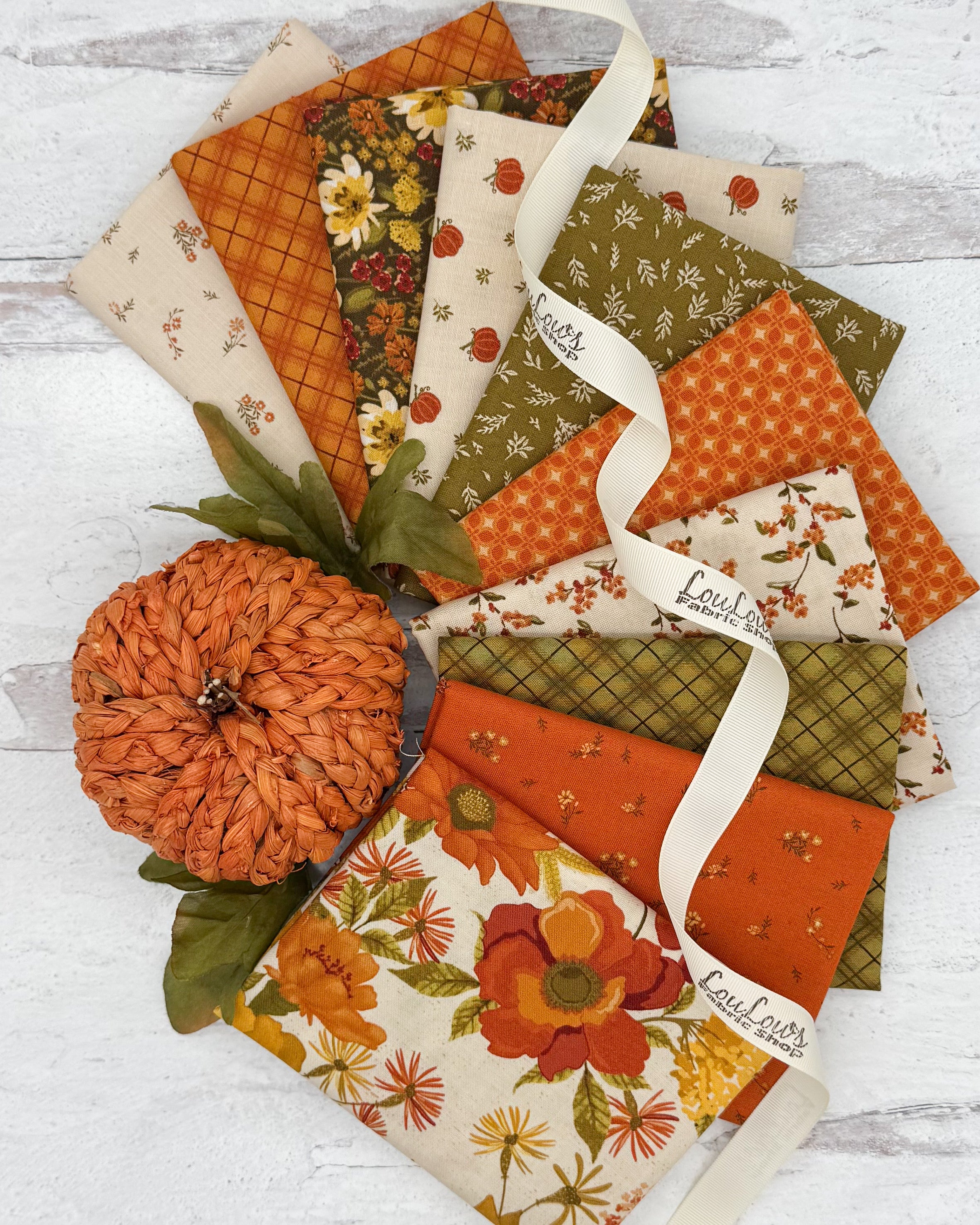 Collection of 10 fall themed fat quarters with backgrounds of cream, orange and olive green. Prints in florals, plaids and pumpkins. 