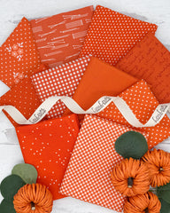 10 bright true orange fat quarters with dot, star, gingham and floral prints. 